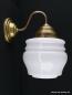 Preview: Schlichte Jugendstil Wandleuchte mit geschwungenem Arm, Material Messing - hell patiniert, tonnenförmig, weiß glänzend, mehrfach eingeschnürt, 1xE27/40W, Spiegel-Badlampe nach unten
