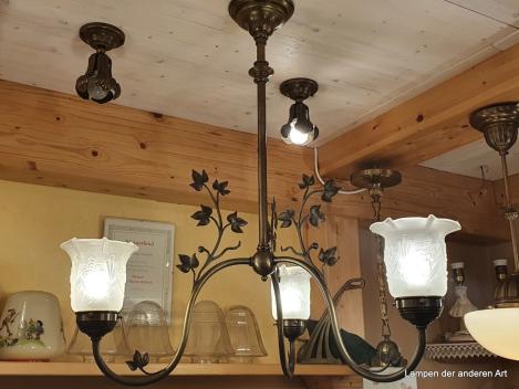 außergewöhnliche antike 3-armige Deckenleuchte aus der Zeit des Jugendstil, drei stilisierte gewundene Blütenstiele mit Blattranken aus Messing, die jeweils in einem satinierten Glasschirm, welcher ebenfalls mit Jugendstilelementen verziert ist, enden