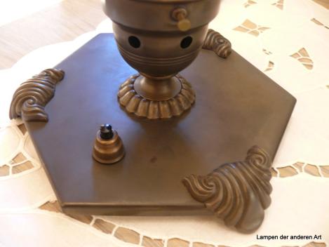 Art Deco Tischleuchte restauriert, Messing dunkel patiniert, sechseckige Gundplatte mit drei rocailleförmigen Füßen, Schirmhalterung mit Belüftungslöchern, gerader zylindrischer Schirm, grau satiniert, längsgerieft, schwarzes Textilkabel, Detail Schalter