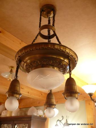 4-flammige Kettenhängeleuchte aus der Zeit des Jugendstils, Messing hell patiniert, 3 Ketten mit Zwischenring, Leuchtenträger mit geprägten Ornamenten, mittig Kuppelglas 1xE27/40W grau satiniert mit Kerbschliff