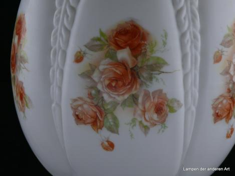 Jugendstil Lampenschirm gebraucht, spitzovaler Glaskörper weiß, mündet in einem stilisiertem Pinienzapfen, reliefierte Zwischenstücke trennen die dazwischenliegenden glatten Felder, die mit orange-roten Rosen und zartgrünen Blättern verziert sind, Detail