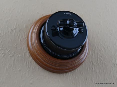 Preview: Garby Aus-Wechsel Porzellandrehschalter schwarz im Einfachrahmen Massivholz Buche honigfarben, von vorn