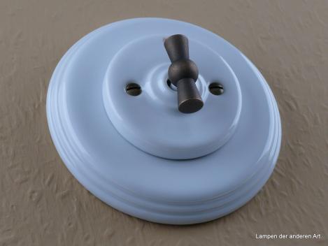 Preview: Garby Colonial Aus-Wechsel Porzellandrehschalter weiß im Einfachrahmen Porzellan weiß Knebel Messing patiniert von vorn