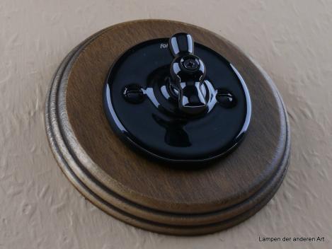 Preview: Garby Colonial Aus-Wechsel Porzellandrehschalter schwarz im Einfachrahmen Holz Buche gealtert Knebel Porzellan schwarz von vorn