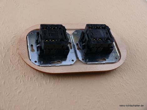 Preview: Garby Colonial 2fach Kombination, 2fach Rahmen Holz Buche honigfarben, zwei Aus-Wechsel-Porzellandrehschalter weiß,  Knebel Messing patiniert, von hinten