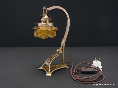Jugendstil Tischleuchte, Messing patiniert, tolles Ornament zwischen Fuß und Leuchtenarm, braunes Textilkabel mit Schnurschalter, Fassung E27 original mit Porzellanring, Jugendstil Lampenschirm goldfarben satiniert, Form einer Rosenblüte