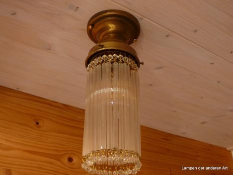 schlichter Jugendstil-Deckenlampenfuß aus patiniertem Messing, bestückt mit längs gerillten Glasröhren mit kugelförmigen Prismenabschluss, 1xE27