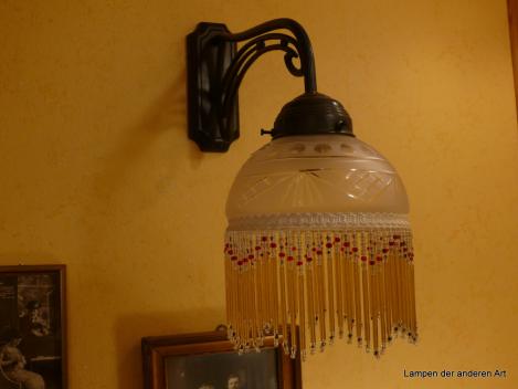 Jugendstil Wandleuchte, 1x E14/40W, Messing dunkel patiniert, Metallfassung, Glasschirm satiniert, Oliven-, Rauten- und Strahlenschliff, Perlfransenbehang, seitlich