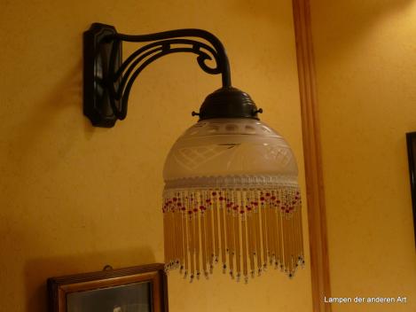 Jugendstil Wandleuchte, 1x E14/40W, Messing dunkel patiniert, Metallfassung, Glasschirm satiniert, Oliven-, Rauten- und Strahlenschliff, Perlfransenbehang