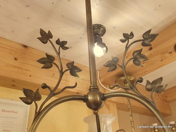antike 3-armige Deckenleuchte aus der Zeit des Jugendstil, drei stilisierte gewundene Blütenstiele mit Blattranken aus Messing, die jeweils in einem satinierten Glasschirm, welcher ebenfalls mit Jugendstilelementen verziert ist, ende - Detail Blattranke