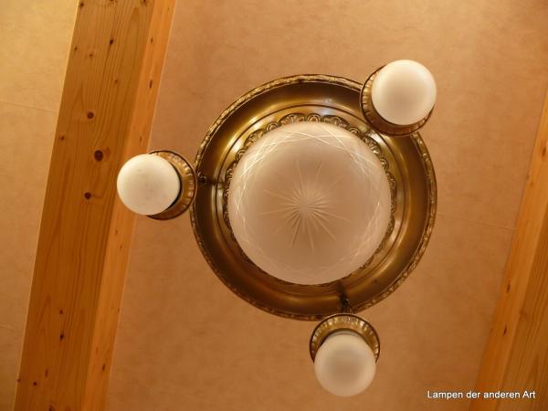 4-flammige Kettenhängeleuchte aus der Zeit des Jugendstils, Messing hell patiniert, 3 Ketten mit Zwischenring, Leuchtenträger mit geprägten Ornamenten, mittig Kuppelglas 1xE27/40W grau satiniert mit Kerbschliff, von unten