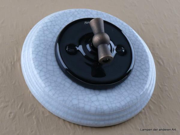 Garby Colonial Aus-Wechsel Porzellandrehschalter schwarz im Einfachrahmen Porzellan craquele Knebel Messing patiniert von vorn