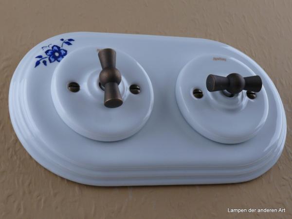 Garby Colonial 2fach Kombination, 2fach Rahmen Porzellan weiß, Dekor Blume blau, zwei Aus-Wechsel-Porzellandrehschalter weiß,  Knebel Messing patiniert