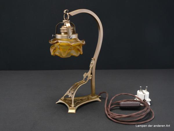 Jugendstil Tischleuchte, Messing patiniert, tolles Ornament zwischen Fuß und Leuchtenarm, braunes Textilkabel mit Schnurschalter, Fassung E27 original mit Porzellanring, Jugendstil Lampenschirm goldfarben satiniert, Form einer Rosenblüte