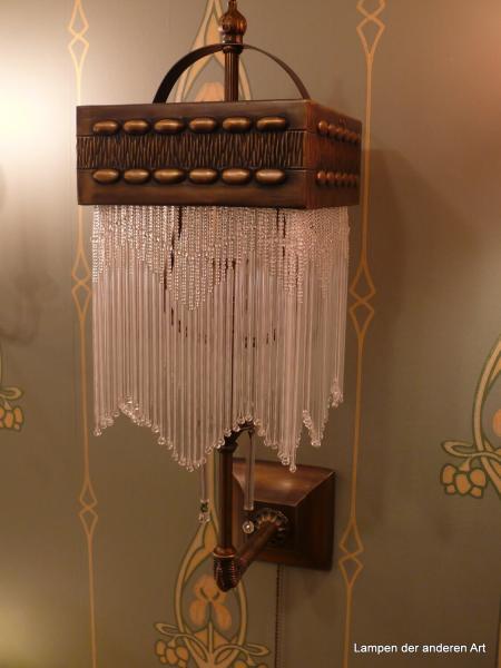 Jugendstil Wandleuchte, Messingfassung 1x E14/40W, Messing dunkel patiniert, quadratischer Blendschirm mit gestuftem Perlfransengehänge, Halter stilisierte Kralle, Zugschalter